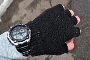 homme à la recherche à montre. Masculin main vêtements par sport tricoté gants avec électronique montre. photo