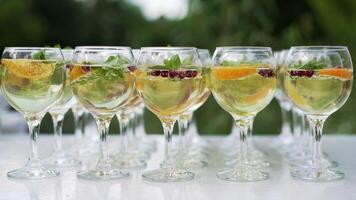 Trois coloré des cocktails dans grand du vin des lunettes dans une classique bar environnement avec douzaines de floue alcool bouteilles dans le Contexte. photo