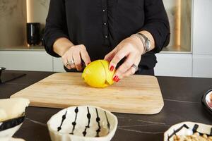 hôtesse Coupe citron dans cuisine pour carpaccio fabrication avec marbre Contexte photo