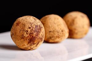 magnifique bonbons truffe sur une blanc assiette sur une noir Contexte photo