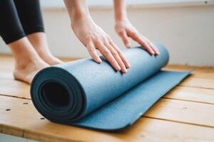 accessoire pour aptitude yoga tapis fermer. mains sur une bleu tapis. photo