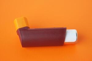 asthme inhalateur sur Orange Contexte. concept, pharmaceutique des produits pour traitement symptômes de asthme ou copd. utilisation en dessous de ordonnance. santé se soucier dispositif à maison. photo