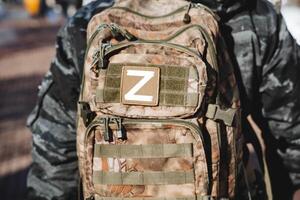 le lettre z Ouest est coup fermer. le la désignation de le occidental troupes, le symbole de le russe armée, le camouflage sac à dos de une militaire soldat. photo