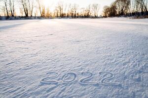 2022 une inscription sur le neige. le Nombres de le année sont écrit dans le neige. Date deux mille vingt-deux. année de le tigre. la glace lac. photo