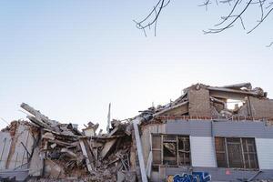 une ruiné maison contre une bleu ciel. le explosion détruit le bâtiment, démoli le maison une bouquet de béton. le conséquences de le catastrophe, le tremblement de terre. photo