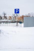 parking espace pour le désactivé. spécial parking lieu. couvert de neige parking espace dans le parking parcelle. photo