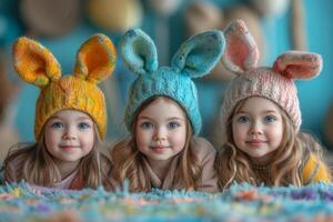 ai généré Trois mignonne peu sœurs sont mensonge sur le sol dans chaud tricoté Chapeaux et lapin oreilles sur bleu Contexte. photo