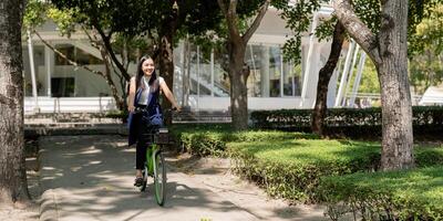 asiatique femme d'affaires dans vélo aller à travail à bureau. bicyclette faire la navette, content femme d'affaires en utilisant éco transport, concept de éco mode de vie photo