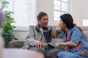 content mature mari et épouse asseoir du repos sur confortable canapé dans vivant pièce prendre plaisir en parlant, souriant personnes âgées couple se détendre sur canapé à Accueil bavarder parler rire sur loisir fin de semaine photo