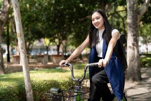 asiatique femme d'affaires dans vélo aller à travail à bureau. bicyclette faire la navette, content femme d'affaires en utilisant éco transport, concept de éco mode de vie photo