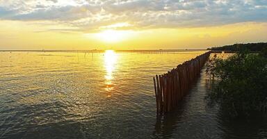 le coucher du soleil plus de mer. bambou digue dans le mer. photo