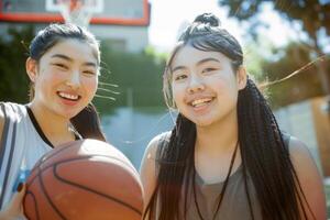 ai généré deux asiatique les filles souriant en plein air en portant une basketball joyeusement, femmes dans des sports compétitions, athlétique excellence, compétitif esprit photo