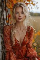 ai généré magnifique blond femme dans rouge orange robe posant par arbre avec coloré feuilles photo