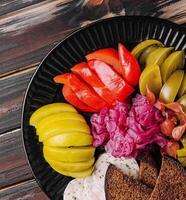 délicieux cornichons épicés coupés sur une assiette de service photo