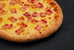 Pizza avec Bacon et fromage sur pierre planche photo