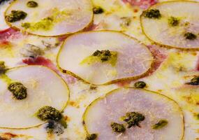 proche en haut Pizza avec poire, fromage et jambon photo