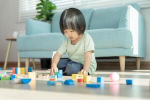 content asiatique enfant en jouant et apprentissage jouet blocs. les enfants sont très content et excité à maison. enfant avoir une génial temps jouant, activités, développement, attention déficit hyperactivité désordre photo