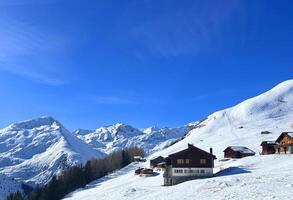 une neigeux Montagne pente avec Maisons sur il photo