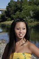 Extérieur portrait souriant asiatique américain femme à rivière photo