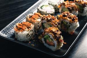 gros plan de rouleaux de sushi sur plateau noir photo