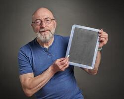 Sénior homme avec Vide tableau noir planche photo