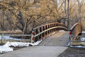 bicyclette Piste et passerelle plus de une rivière dans hiver ou de bonne heure printemps - cache la poudre rivière dans fort collins, Colorado photo