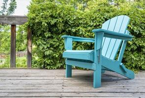 vide adirondack chaise sur une en bois arrière-cour pont, été paysage avec une vert vigne photo