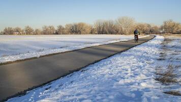 Masculin cycliste faire la navette sur une bicyclette Piste dans hiver paysage - poudre rivière Piste dans nord Colorado entre windsor et greley photo