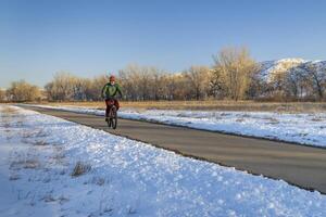 Sénior Masculin cycliste sur une bicyclette Piste dans hiver paysage - poudre rivière Piste dans nord Colorado, Cyclisme, des loisirs et faire la navette concept photo