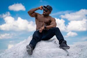 musclé fort bodybuilder posant pour caméra. Beau athlétique homme sur le bleu ciel. photo