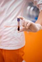 tester tube plein de du sang pour vérification corona virus. scientifique tenir une du sang goûter. photo