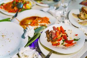 le laissé pour compte nourriture et sale vaisselle sur le restaurant tableau. restes la gauche plus de après le faire la fête. photo