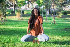 souriant femme est Faire yoga exercice à l'extérieur dans une parc. concept de en bonne santé mode de vie. photo