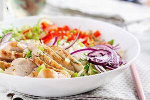 Frais salade avec grillé poulet sein, filet et laitue, daïkon, rouge oignons, concombre et sésame. en bonne santé le déjeuner menu. régime aliments. photo