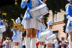 majorettes avec blanc et bleu uniformes effectuer dans le des rues de le ville. photographique séries photo