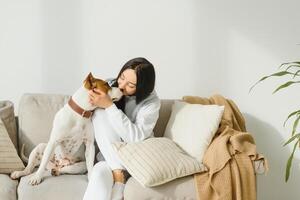 Jeune femme avec sa mignonne chien à maison. charmant animal de compagnie. photo