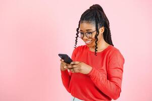 africain américain femme plus de isolé rose Contexte Envoi en cours une message avec le mobile. photo