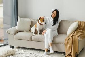 Jeune femme avec sa mignonne chien à maison. charmant animal de compagnie. photo