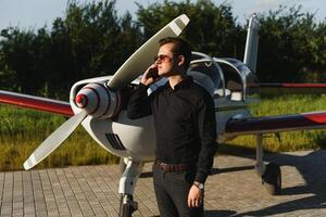 Jeune Beau homme d'affaire est permanent près privé avion. sur de soi et réussi homme dans aéroport. photo