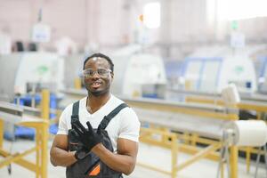 portrait de africain américain Masculin ingénieur dans uniforme et permanent dans industriel usine photo