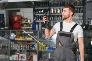 auto les pièces magasin. le vendeur reçoit le produit et évalue le qualité photo