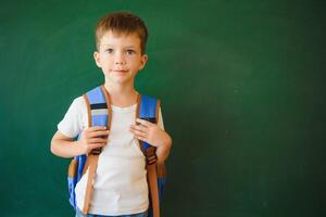 retour à école. marrant peu garçon près tableau noir. enfant de élémentaire école. éducation. photo