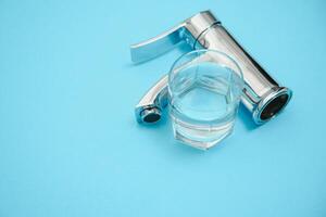 Célibataire manipuler l'eau robinet sur lumière bleu Contexte. Nouveau chrome ou acier mixer robinet . photo
