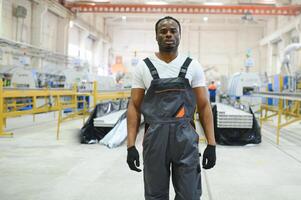 travailleur industriel à l'intérieur de l'usine. jeune technicien avec casque orange photo