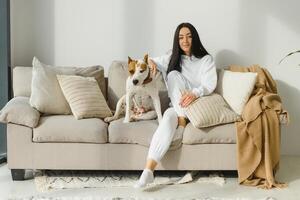 Jeune femme avec sa mignonne chien à maison. charmant animal de compagnie. photo