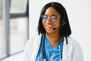 Jeune Afro-américain médecin travail sur portable dans clinique. photo