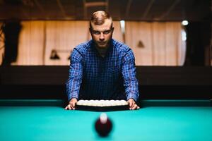 Jeune homme en jouant billard. dépenses gratuit temps sur jeux d'argent photo