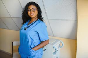 jolie femelle africain médecin avec bras franchi à hôpital photo