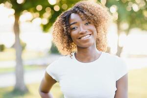 une Jeune femelle Afro-américain femme profiter une journée à le parc photo