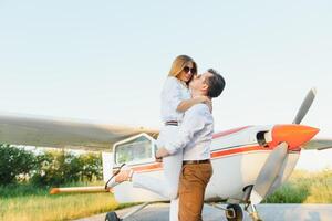 couple dans l'amour étreindre près privé avion. sélectif concentrer photo